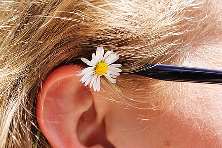 close up photography of white petaled flower placed on human ear thumbnail