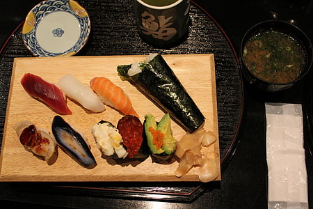 sushi and sashimi on brown wooden chopping board thumbnail
