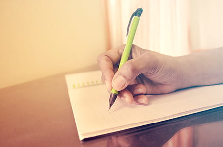 Writing on notebook with pencil thumbnail