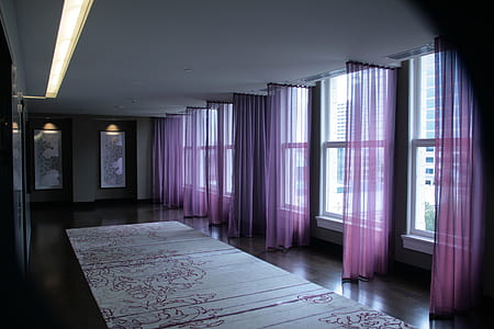 room with purple curtains and floral area rug thumbnail