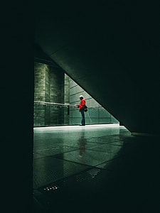 person standing beside glass railings thumbnail