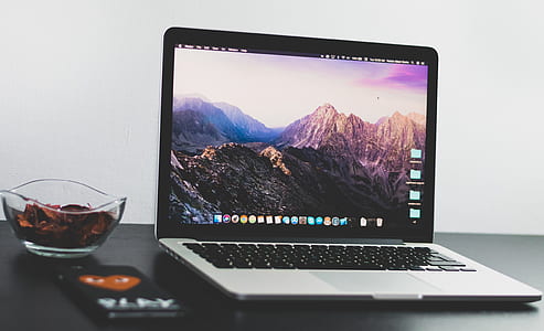 MacBook on table near smartphone thumbnail