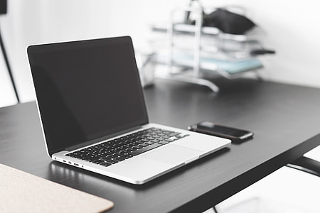 Modern Laptop and Smartphone on Black Desk thumbnail