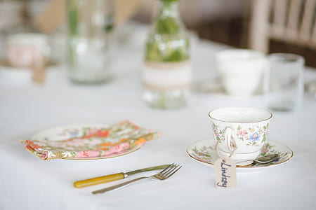 white ceramic cup and saucer near fork and butter knife on table thumbnail
