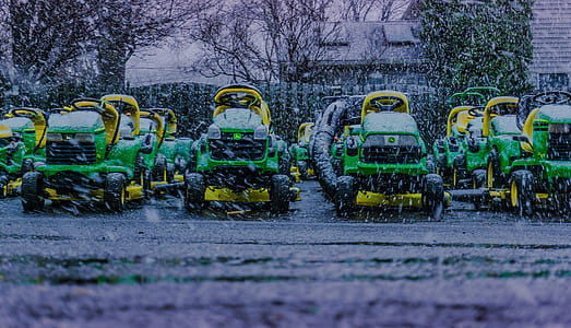 John Deere ride-on mowers parked on snow thumbnail