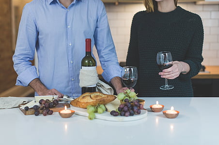 man and woman standing in front of wine bottle and glasses thumbnail