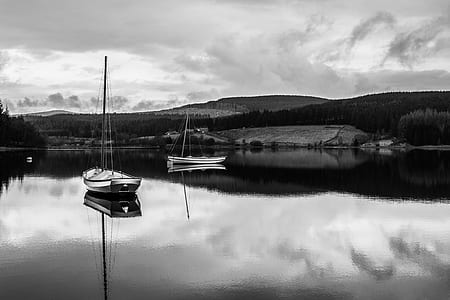 grayscale photography of two boats on calm body of water thumbnail