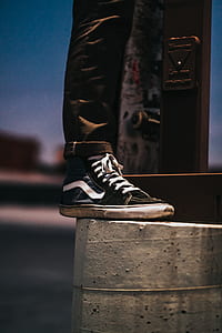 person wearing black and blue Vans Sk8-Hi sneaker on right foot thumbnail