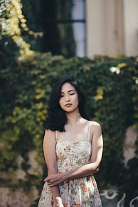 woman wearing white and orange floral spaghetti strap dress near plant thumbnail