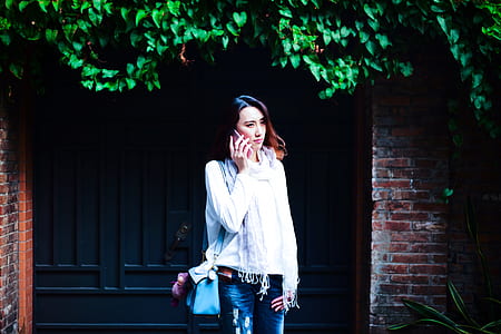 woman holding smartphone in front of the gate thumbnail