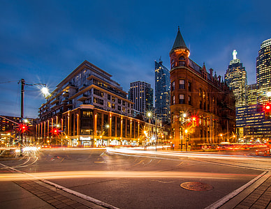 time lapse photography of road beside buildings under night sky thumbnail