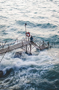 woman sitting on dock during daytime thumbnail