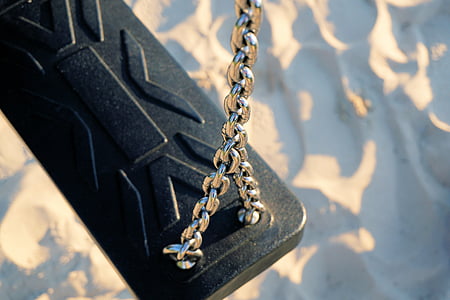 gray metal chain with black case near blue and white surface thumbnail