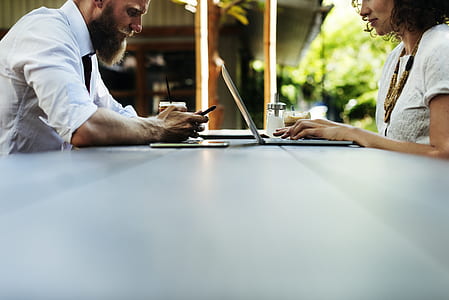 shallow focus photography of man and woman leaning on table thumbnail