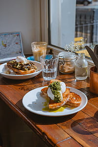 breakfast meals on white plates in front of window thumbnail