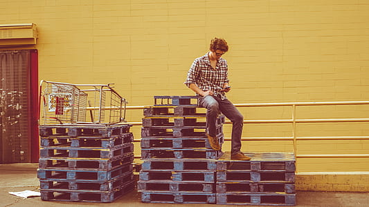 man sitting on wooden pallets thumbnail