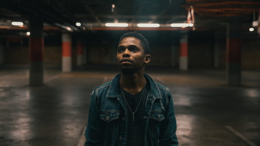 man in blue denim button-up jacket inside building thumbnail