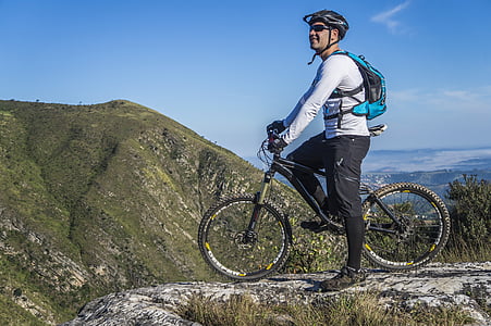 man in white shirt riding bicycle on hill thumbnail