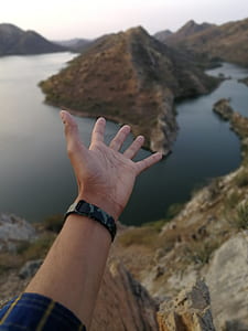 person's opened hands above mountain near river thumbnail