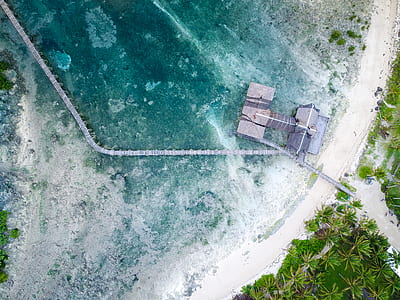 aerial photography of gray wooden dock on sea during daytime thumbnail