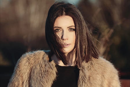 woman wearing fur coat and black top during windy day thumbnail