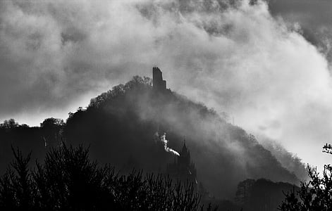 cathedral beside mountain under cloudy sky thumbnail