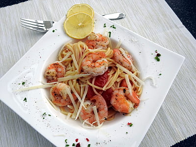 shrimp pasta on white plate with lemon garnish thumbnail