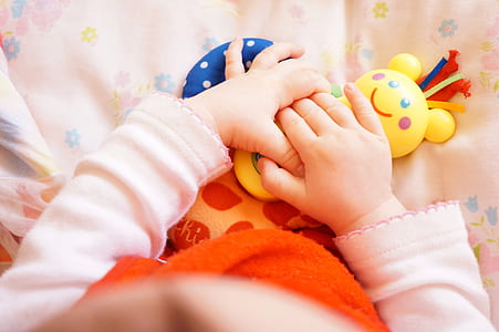 toddler holding a yellow toy thumbnail