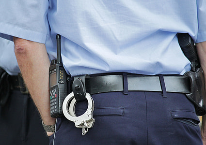 person wearing cop uniform with handcuff and two-way radio thumbnail