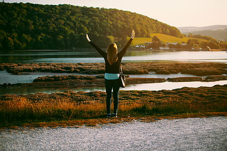 Woman Wearing Black Jacket Standing on Grass Field thumbnail