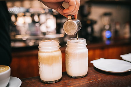 person pouring liquid on two clear glass mason jars thumbnail
