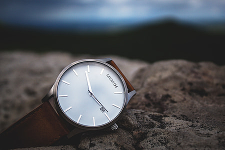 round white Mvmtm analog watch with brown strap selective focus photography thumbnail