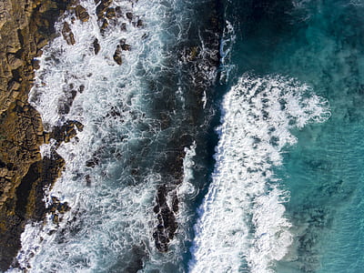 bird's eye view of boulders on body of water thumbnail