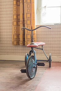 toddler's red and blue trike near window thumbnail