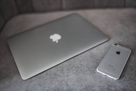 Elegant grey sofa with a laptop, an iPhone and a magazine thumbnail
