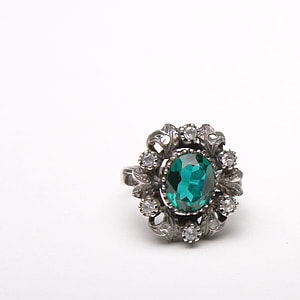 white green gemstone halo ring on white surface thumbnail