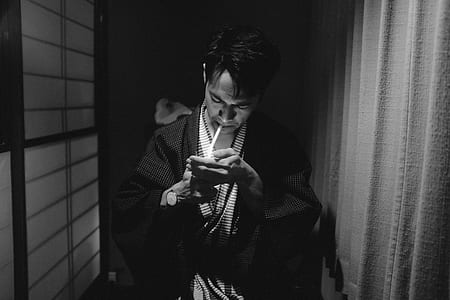 grayscale photo of man lighting cigarette thumbnail