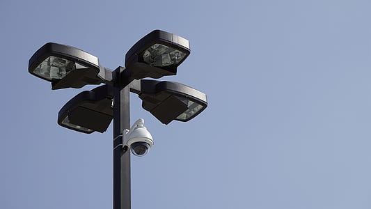 white surveillance camera mounted on black post thumbnail