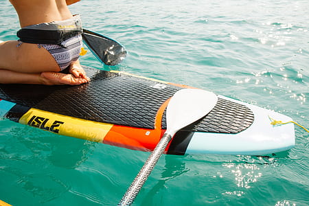 woman on white and multicoloired surfboard at daytime thumbnail