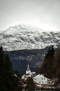 houses near mountain range covered with snows thumbnail