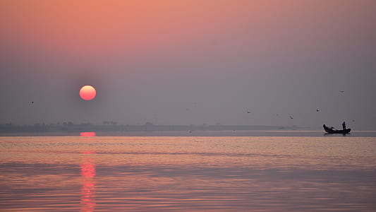 fisherman on boat with sunset thumbnail