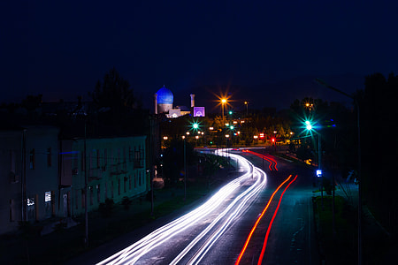 timelapse photography of vehicle passing near buildings thumbnail