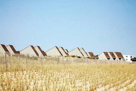 brown-and-white houses near field during daytime thumbnail