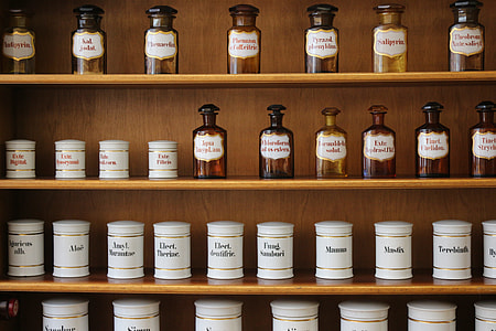 white labeled bottle and jar lot on brown wooden shelves thumbnail