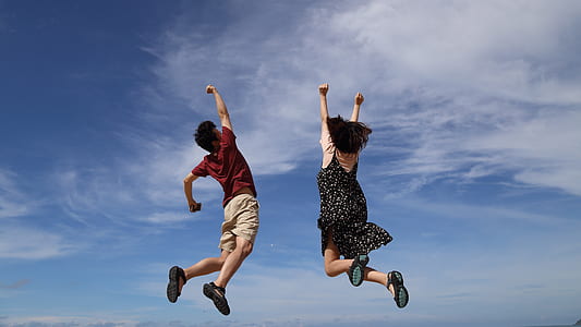 man and woman jumps with hands upwards thumbnail