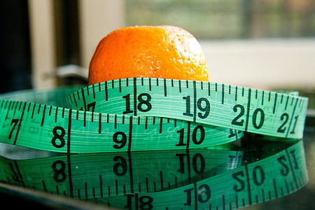 orange fruit wrapped by tape measure thumbnail