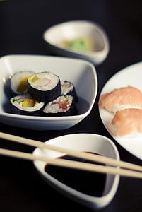 sushi in bowl beside sauce and chopsticks thumbnail