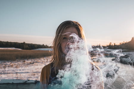 woman smoking near bodies of water during daytime thumbnail