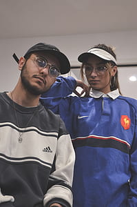 woman wearing blue Nike collared top beside man wearing gray and black adidas sweater thumbnail