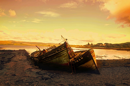 two brown boats dock on beach sand during golden hour thumbnail